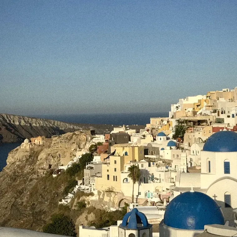 Oia's whitewashed houses and blue church domes above the Santorini caldera