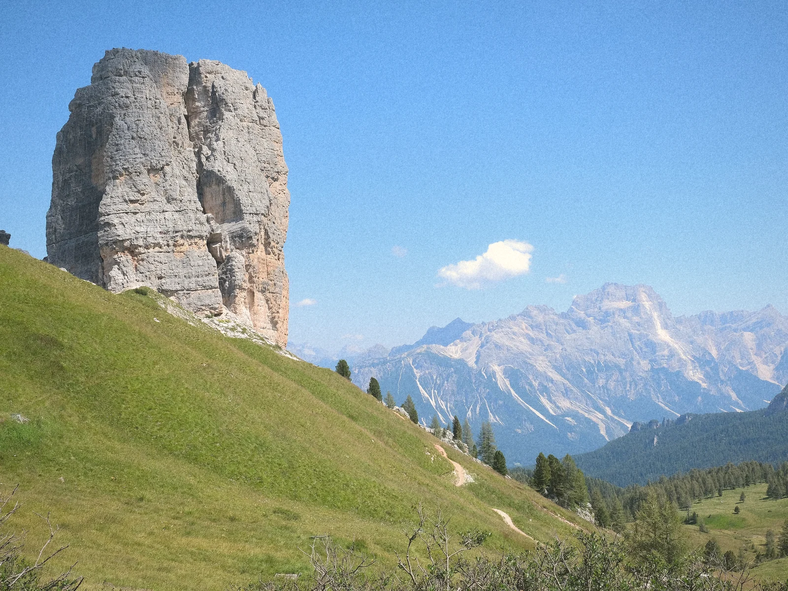 The five rock towers of Cinque Torri rising above alpine meadows