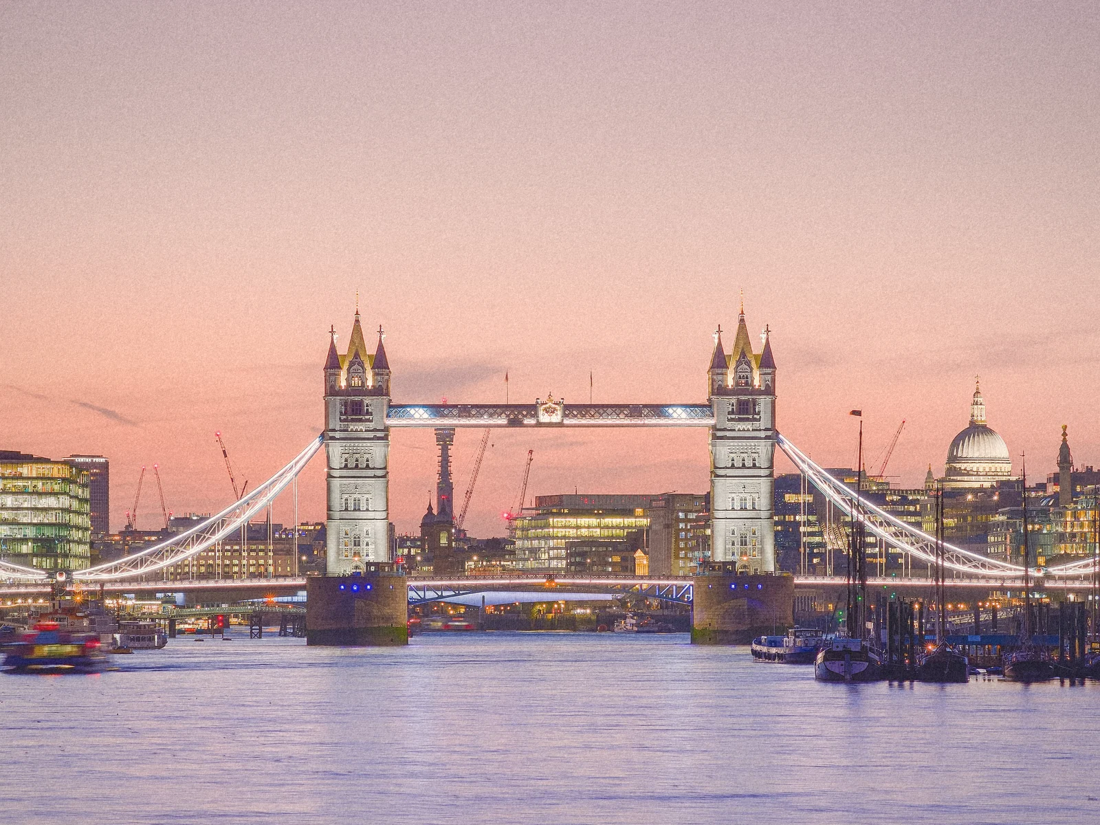 Tower Bridge over the Thames under a pink dusk sky
