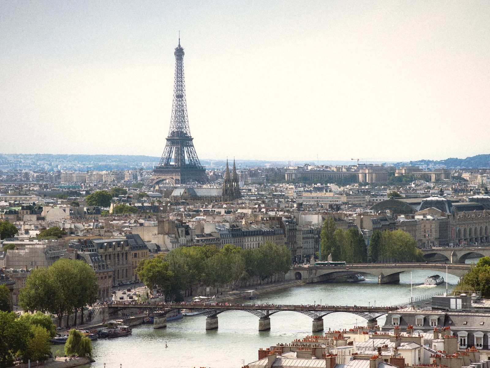 The Eiffel Tower rising above Paris rooftops and the bridges of the Seine