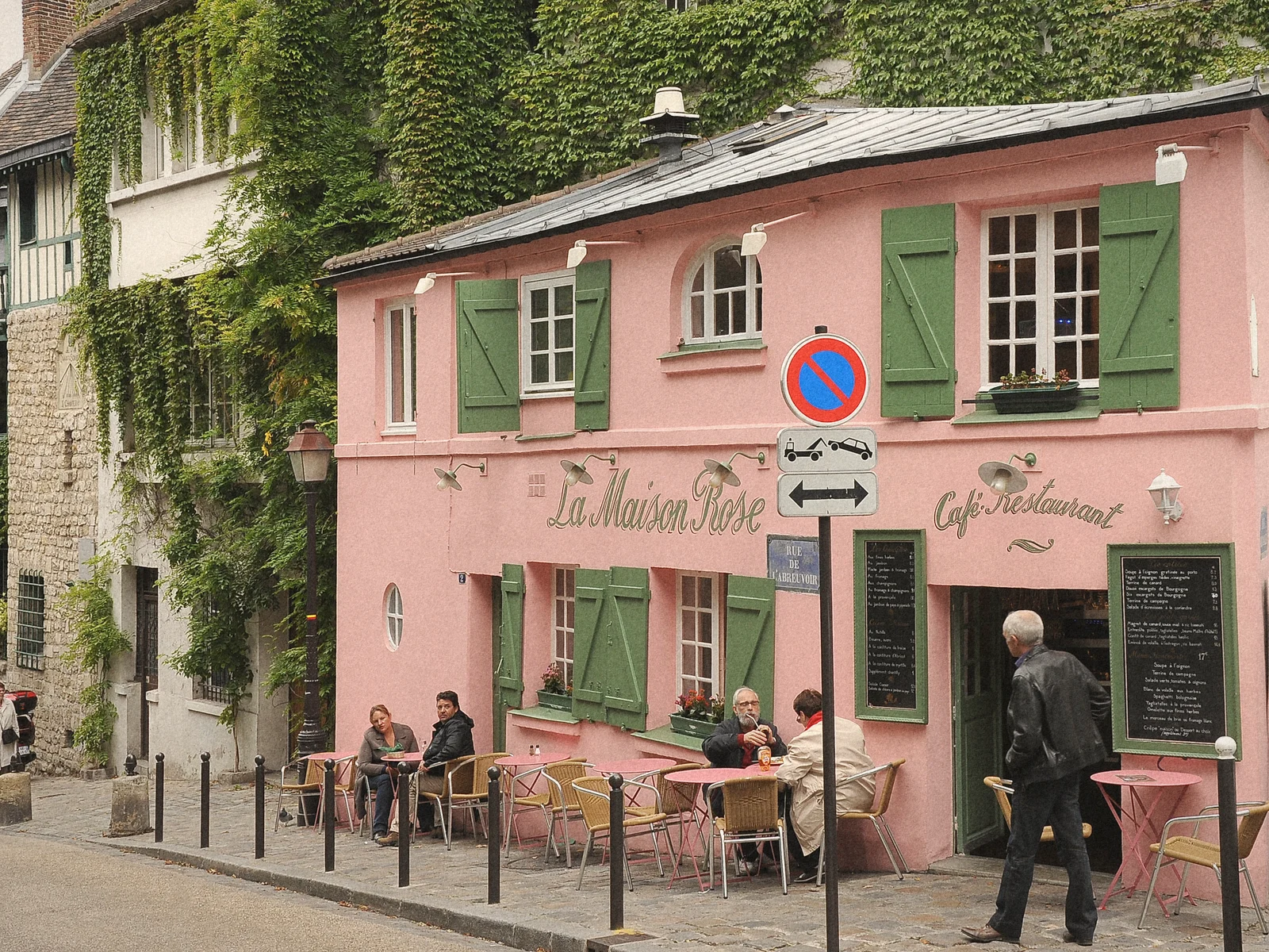 The pink La Maison Rose café with green shutters on a Montmartre corner