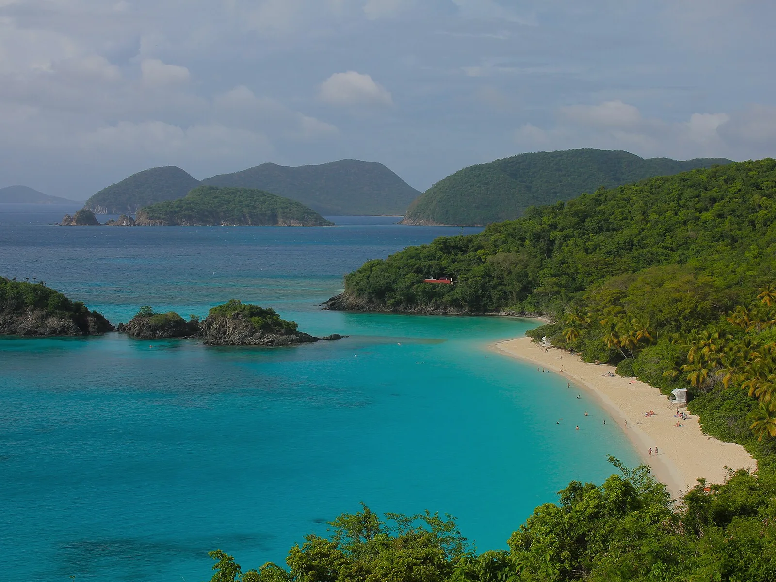 The white crescent of Trunk Bay on St. John, framed by green hills and turquoise water