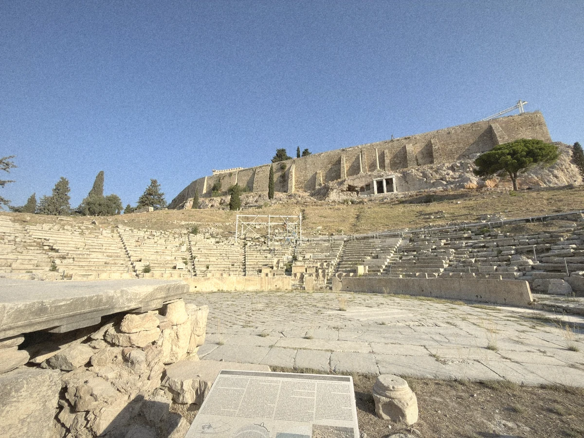 The tiered stone seats and marble floor of the Theatre of Dionysus below the walls of the Acropolis
