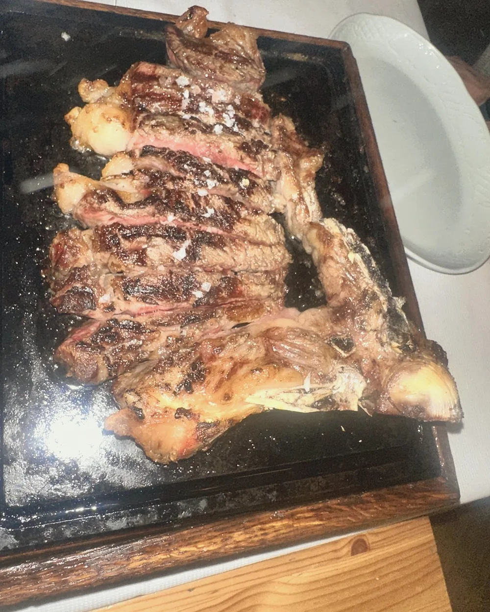 Sliced bistecca alla fiorentina, cooked rare, on a hot plate at Trattoria Dall'Oste