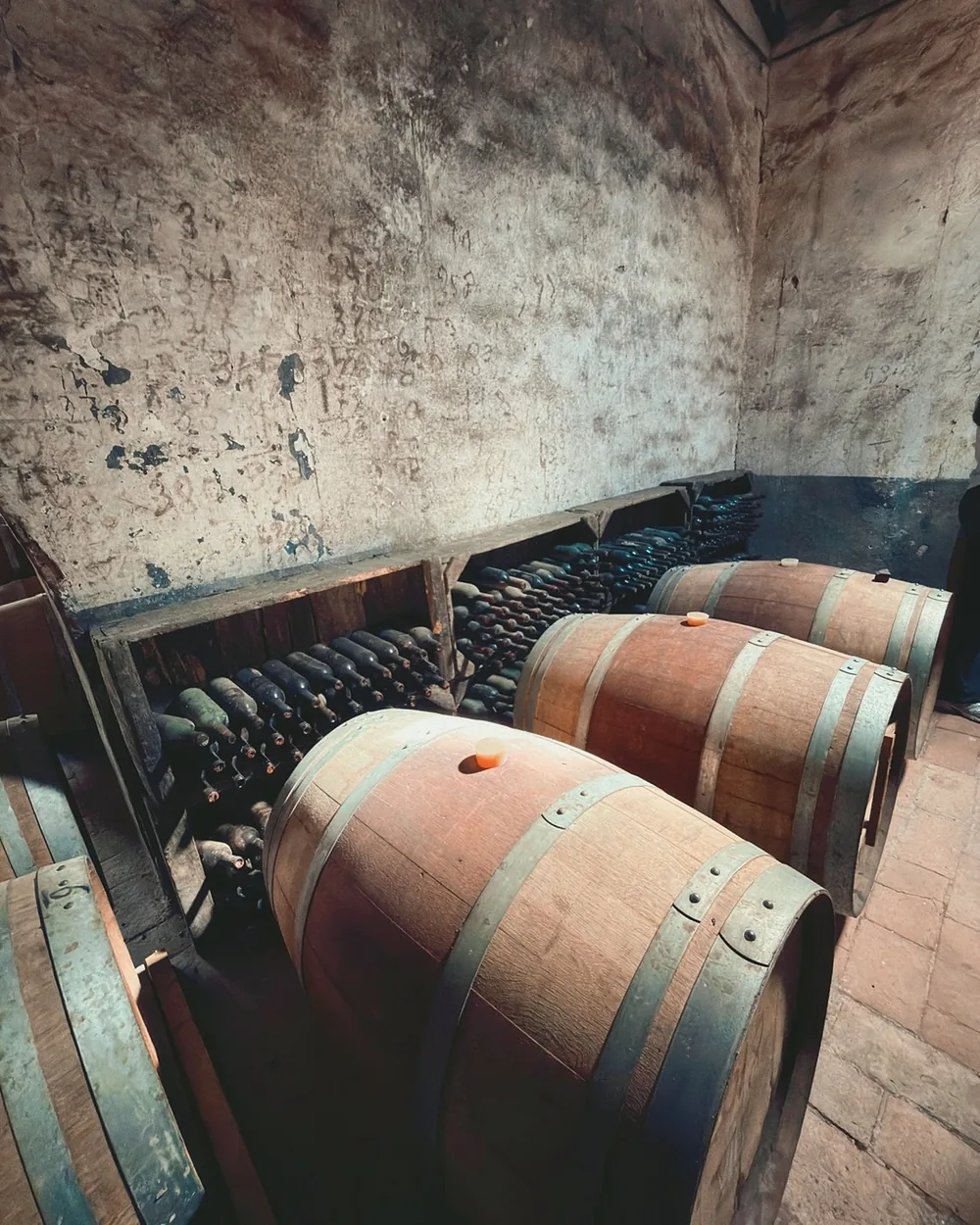 Oak barrels in a stone cellar at Villa Le Corti