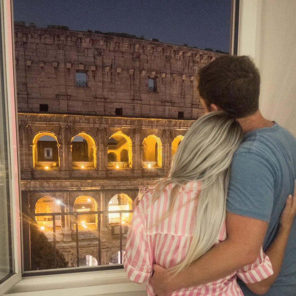 Looking out at the Colosseum lit up at night from the apartment window