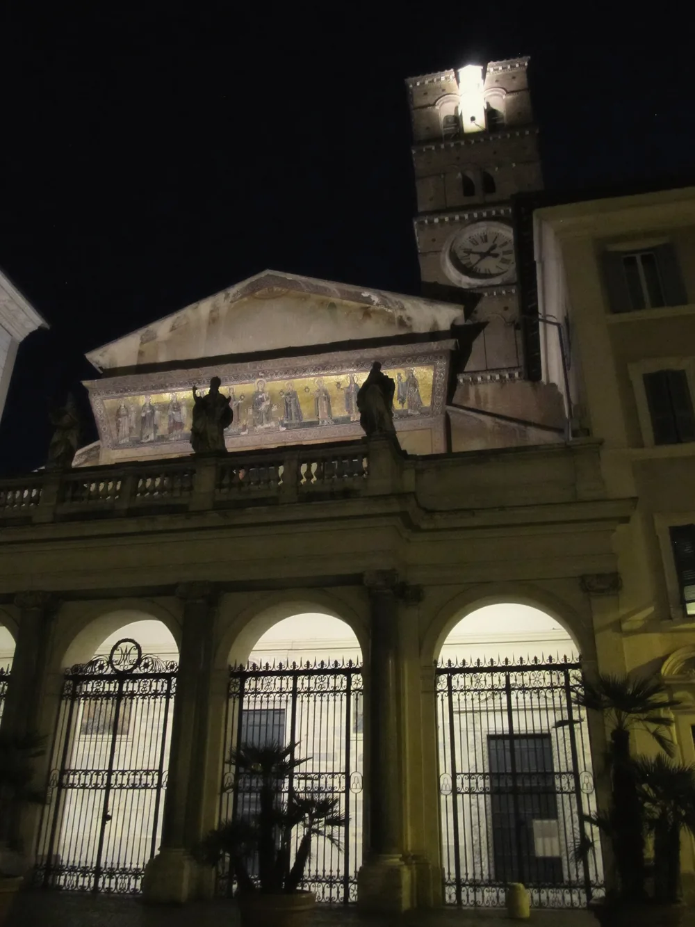 The illuminated facade and bell tower of Santa Maria in Trastevere at night