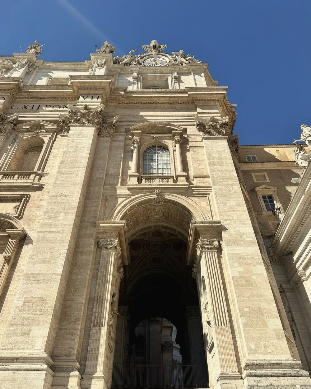 A grand doorway in the travertine facade of St. Peter's Basilica