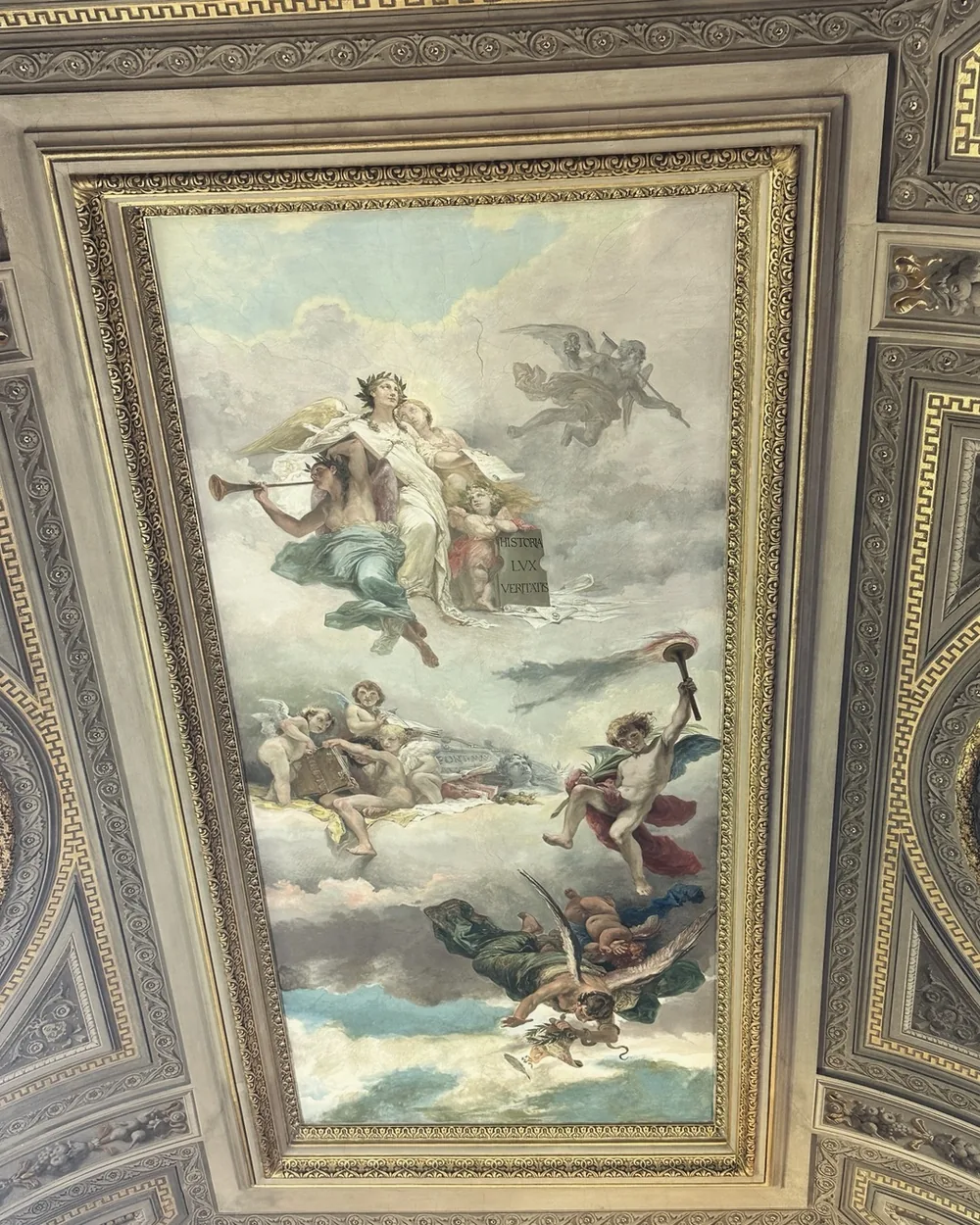 A ceiling painting in an ornate gold frame in the Vatican Museums