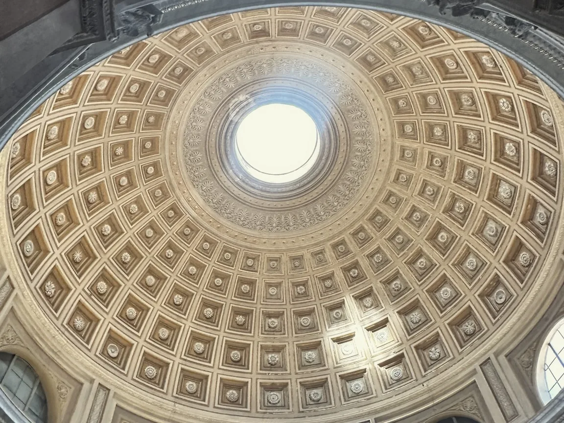 The coffered dome of the Round Room in the Vatican Museums, with light pouring through the oculus